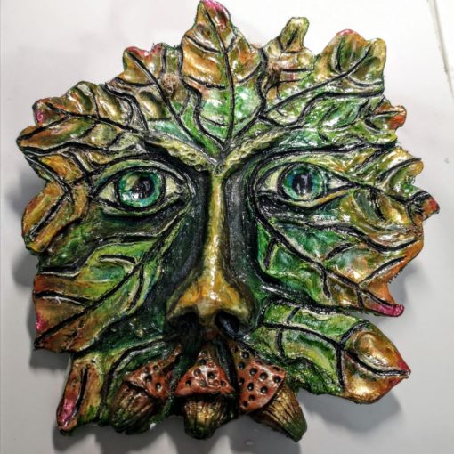 Photo of a clay green man with 3 acorns