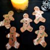 5 zombie clay gingerbread man on a black background with a candle and skull decoration.